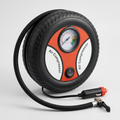 AI-styled portable car air compressor with analogue gauge, hose and vehicle power plug